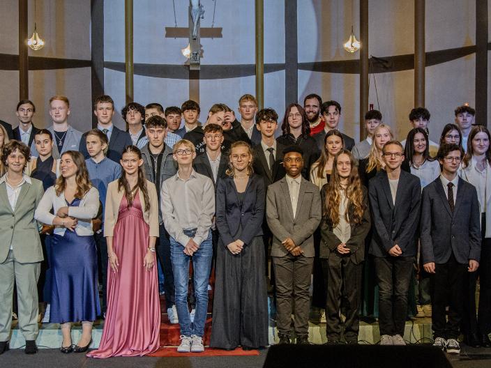 Gruppenfoto der Firmlinge im Hintergrund steht Firmspender Dominic Lück