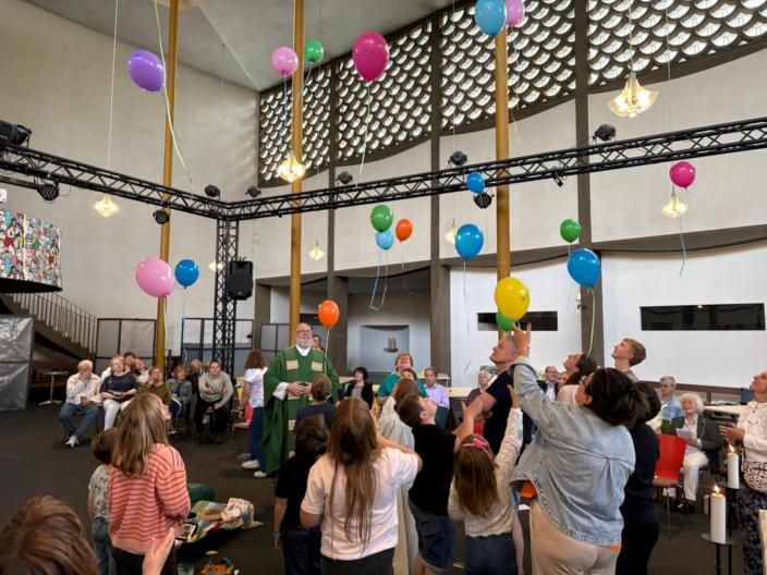 Kinder, Jugendliche, Erwachsene lassen im Gottesdienst in der St. Elisabeth Kirche, Koblenz Rauental bunte Luftballons steigen