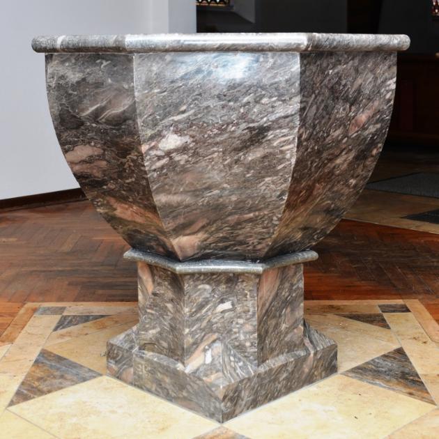 Taufbrunnen ist restauriert und mit Sockel zu sehen, in der Taufkapelle der Kirche